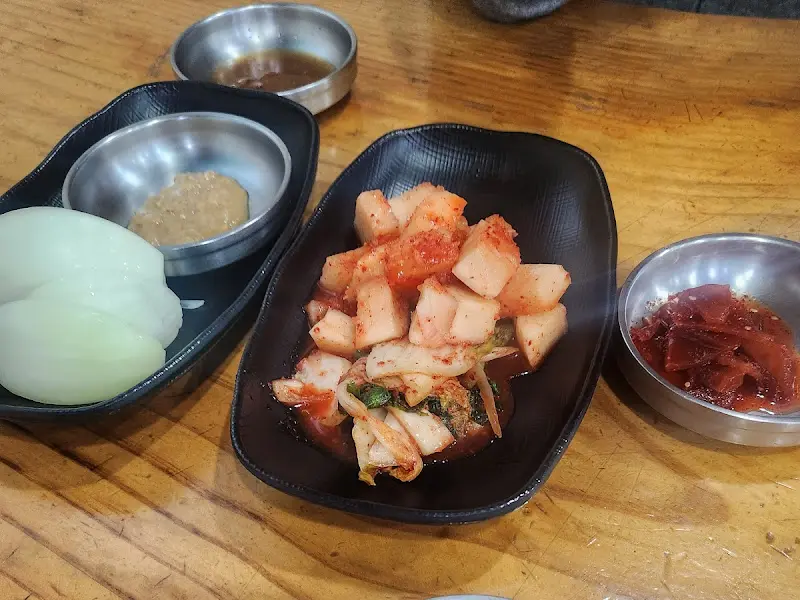 잘 익은 깍두기와 김치, 양파, 무 진미채가 담긴 밑반찬