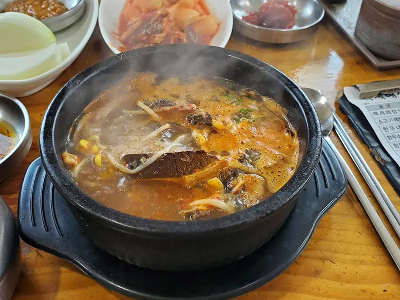 해장국에 밥을 말아 깍두기를 올려 먹는 모습