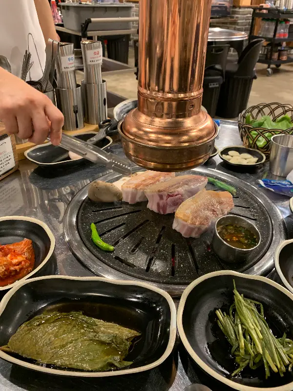 숯불 위에서 익어가는 오겹살과 밑반찬