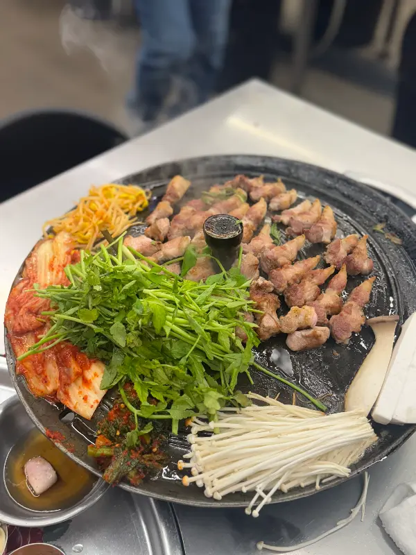 솥뚜껑 위에 푸짐하게 차려진 삼겹살 한 상