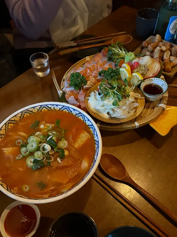 연어 사시미와 곱창 전골이 놓인 테이블 전경