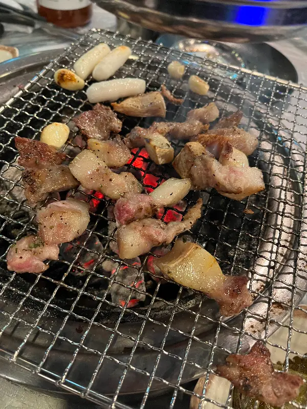 불판 위에서 익어가는 뽈살과 떡, 마늘