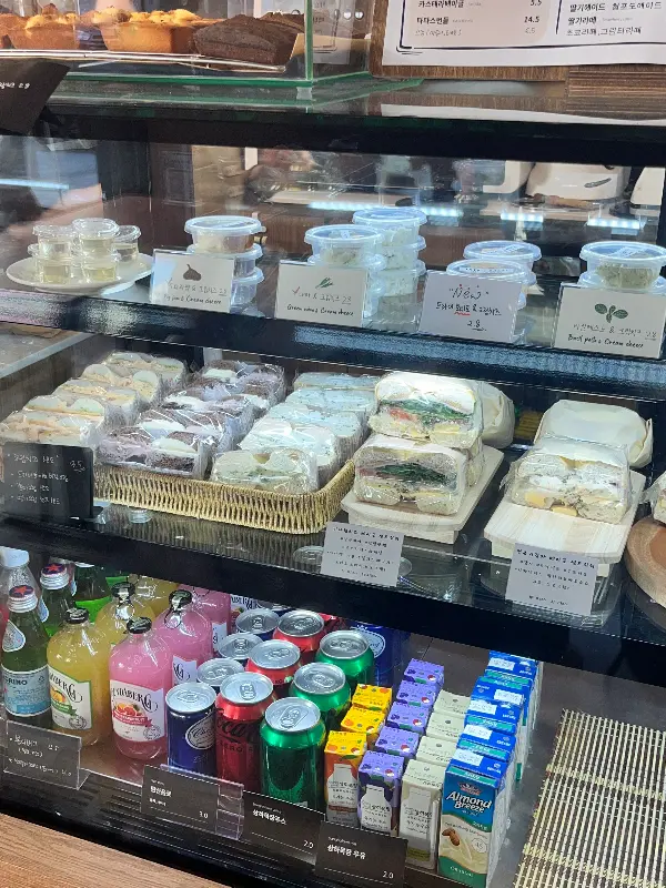 다양한 베이글과 크림치즈, 음료가 진열된 쇼케이스