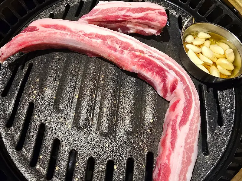 숯불 위에서 노릇노릇하게 구워지고 있는 본삼겹살