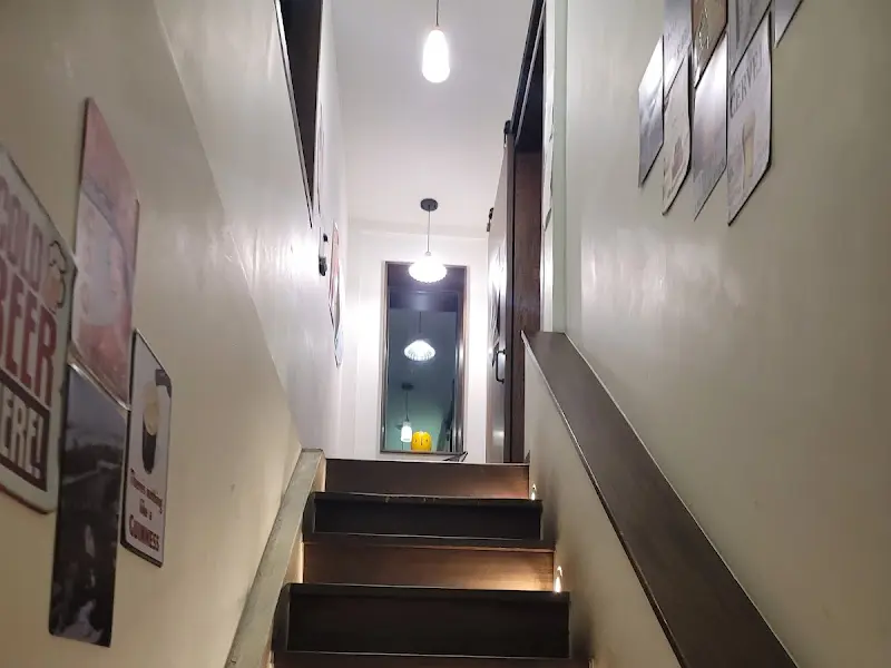 가게 내부로 올라가는 계단 사진, 은은한 조명과 벽에 걸린 사진들이 인상적이다.