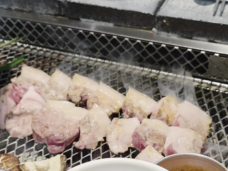 숯불 위에서 구워지는 흑돼지 오겹살