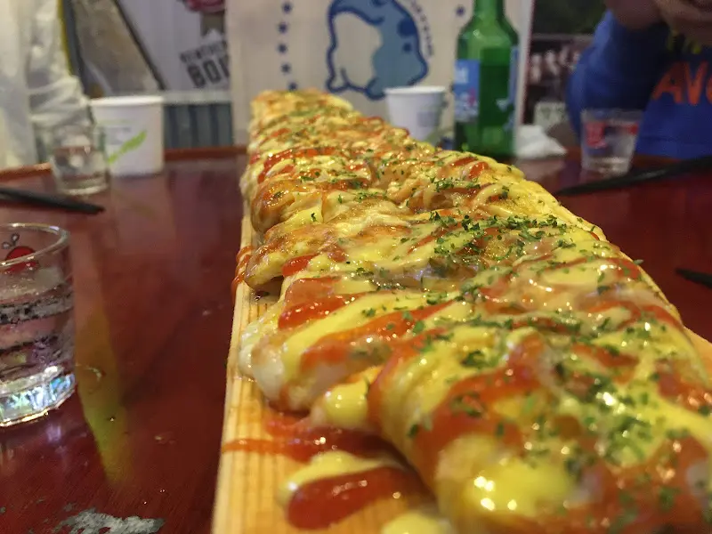 길다란 나무 판에 놓인 치즈 계란말이