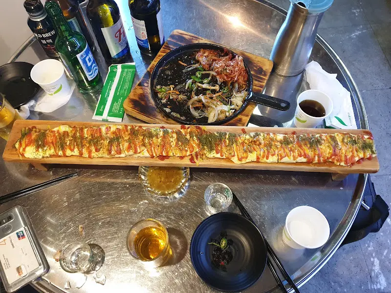 테이블 위에 놓인 치즈 계란말이와 술