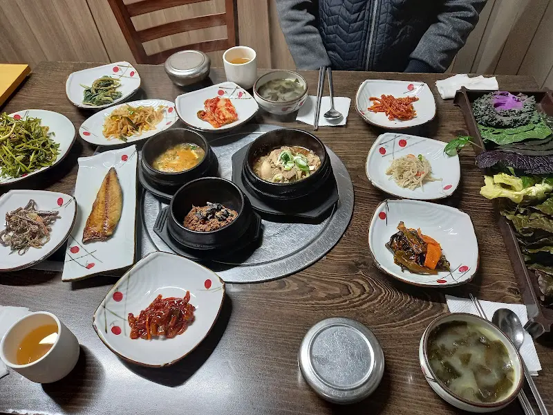 싱싱한 쌈 채소와 다채로운 밑반찬이 테이블을 가득 채운 모습