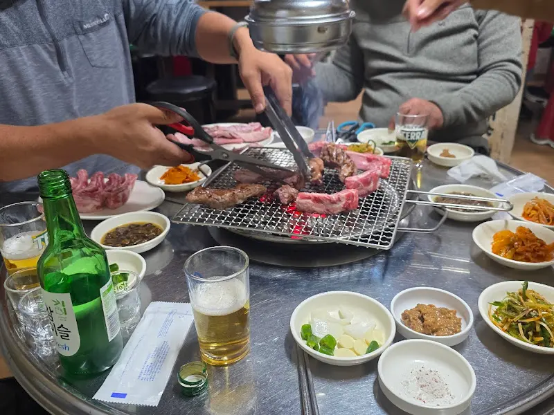 숯불 위에서 익어가는 갈매기살과 푸짐한 밑반찬