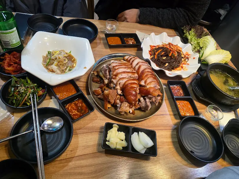 테이블 가득 차려진 족발, 막국수, 밑반찬