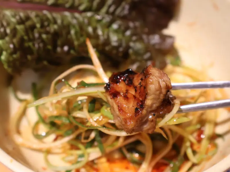 잘 구워진 돼지갈비를 쌈 채소와 함께 먹는 모습