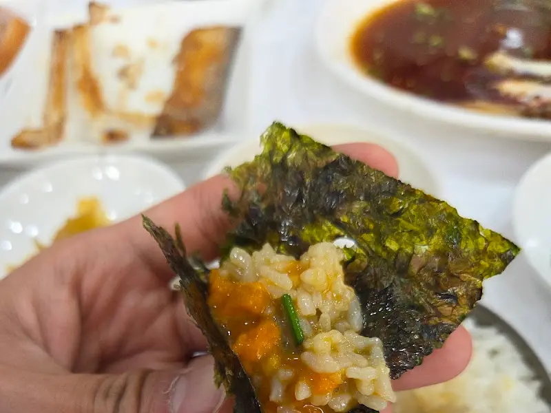 김에 밥과 게장을 싸 먹는 모습