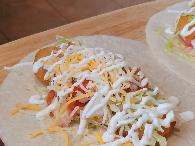 또띠아 위에 각종 재료가 듬뿍 올려진 타코