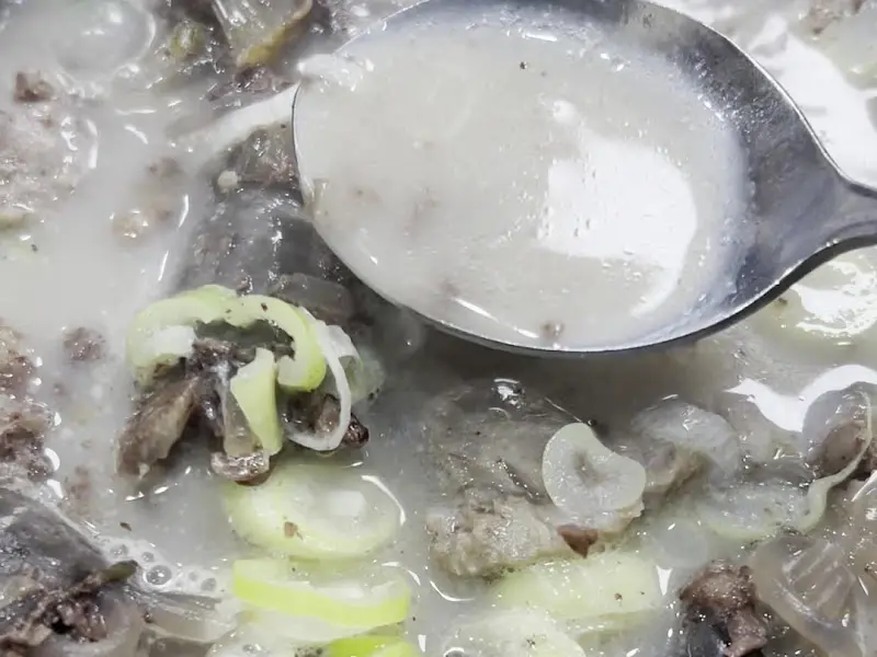 숟가락으로 떠올린 뽀얀 국물