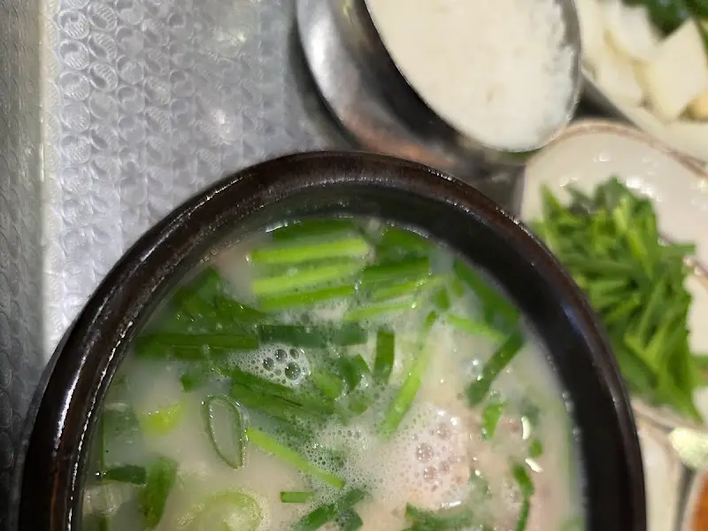 돼지국밥에 부추를 넣어 먹는 모습