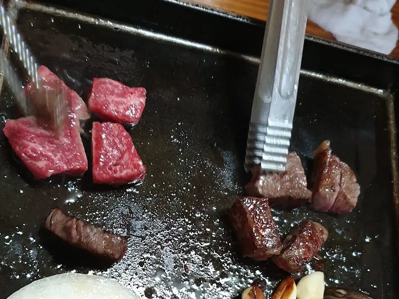 잘 구워진 고기를 집게로 집는 모습