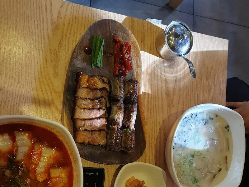 테이블 위에 놓인 매운 고기국수, 사골 고기국수, 돔베수육과 돔베순대의 모습. 푸짐한 한 상 차림이다.