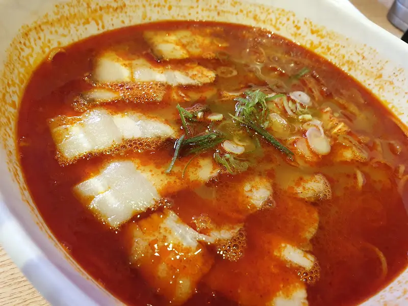 매운 고기국수의 클로즈업 사진. 고기와 면, 파가 잘 어우러져 있다.