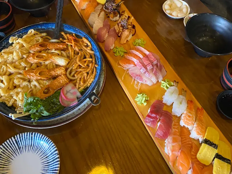 테이블 위에 놓인 푸짐한 초밥과 우동