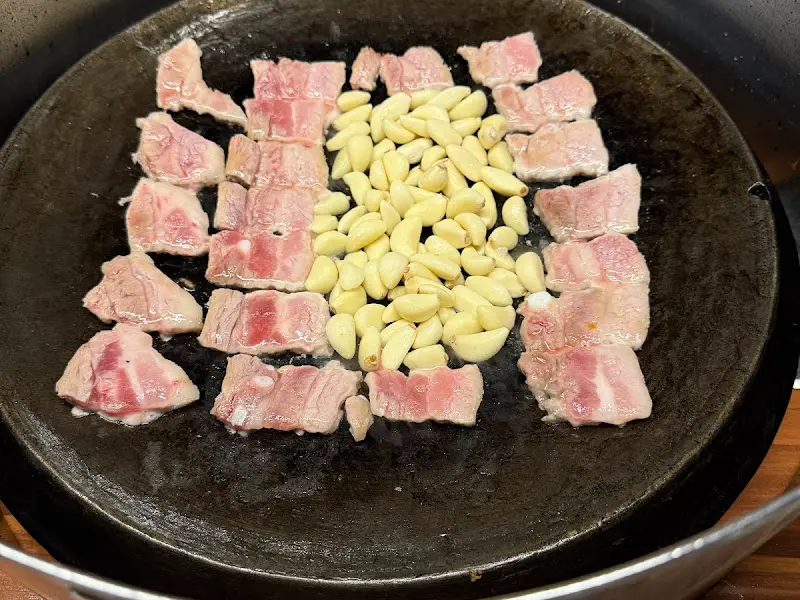 무쇠판에 구워진 삼겹살과 마늘