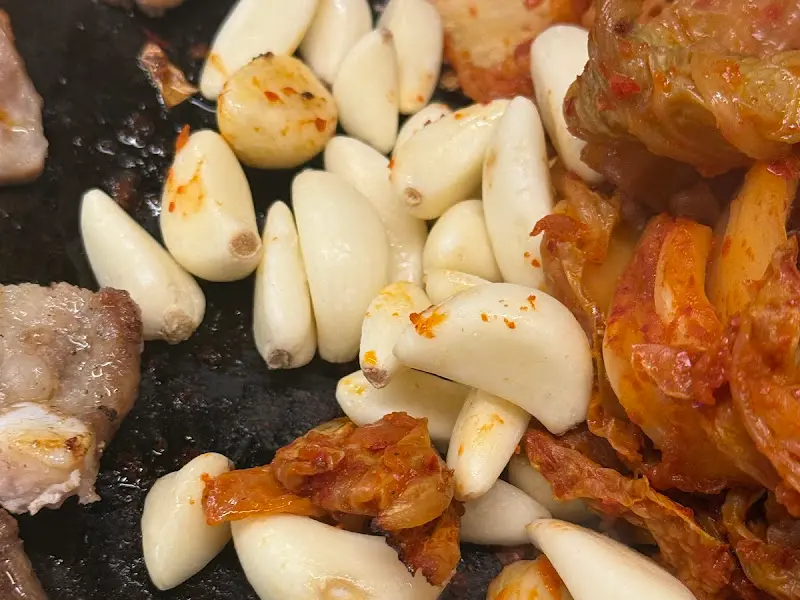 무쇠판에 구워지는 김치와 마늘