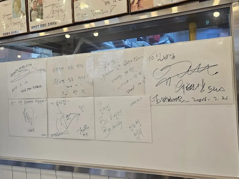 벽면에 빼곡하게 붙어있는 유명인들의 사인