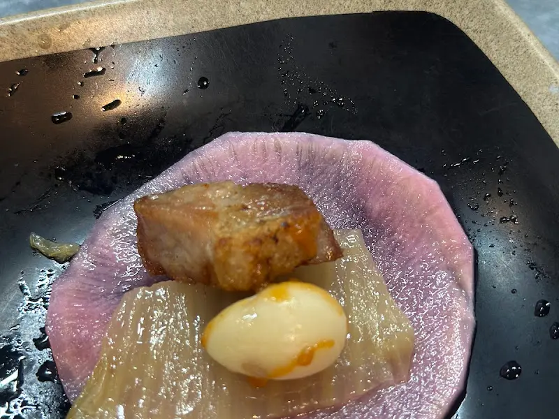 잘 구워진 꼬들살 한 점을 깻잎 장아찌에 싸서 먹는 모습