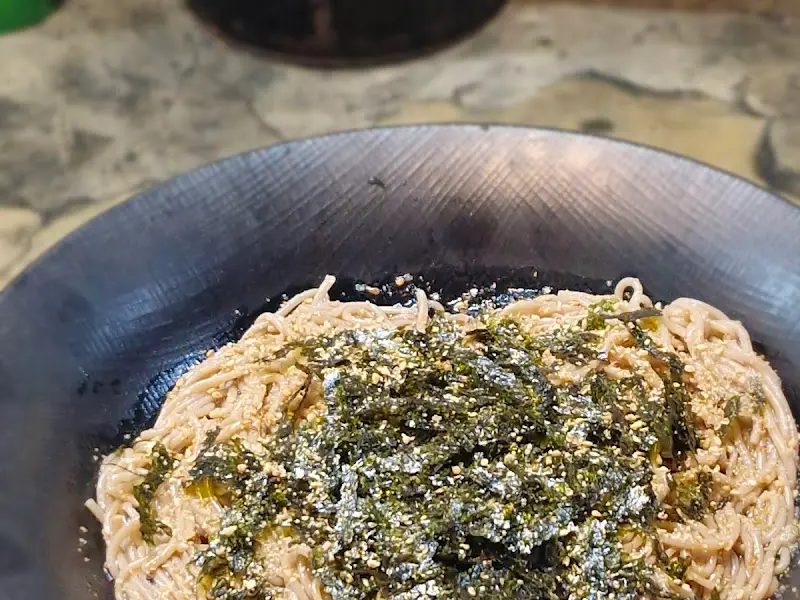 들기름 막국수의 클로즈업 샷, 김가루와 깨가 듬뿍 뿌려져 있다