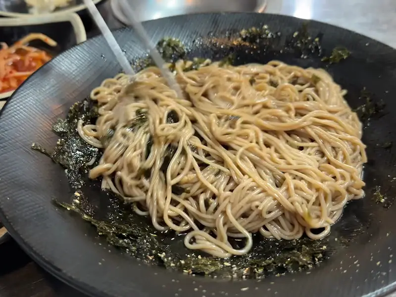 비빔 막국수를 젓가락으로 들어올리는 모습, 쫄깃한 면발이 눈에 띈다