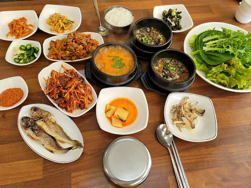 다양한 반찬과 쌈 채소가 함께 제공되는 우렁이 정식