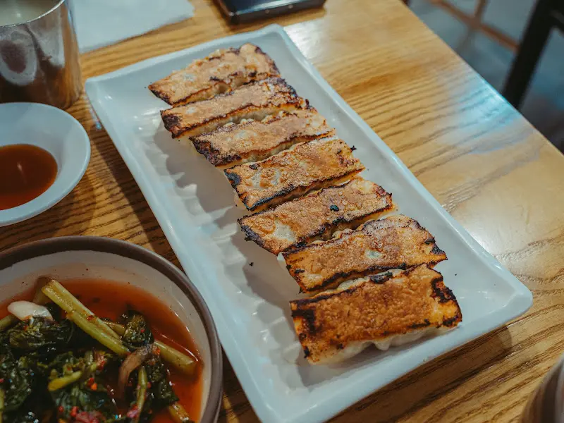 노릇하게 구워진 지짐 만두와 열무김치의 모습