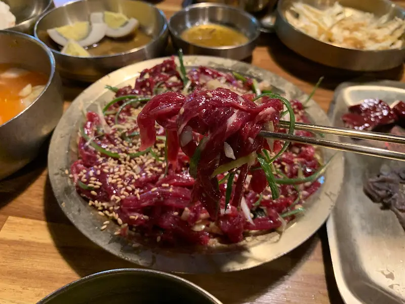 젓가락으로 뭉티기를 들어올리는 모습