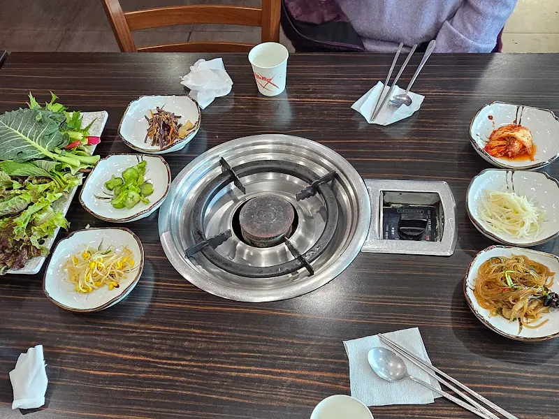 다양한 쌈 채소와 밑반찬이 푸짐하게 차려진 테이블