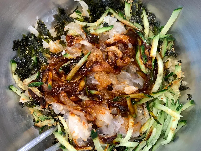 물회에 고추장을 넣어 비비는 모습