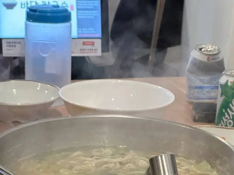 테이블에 놓인 칼국수 냄비 사진. 김이 모락모락 난다.