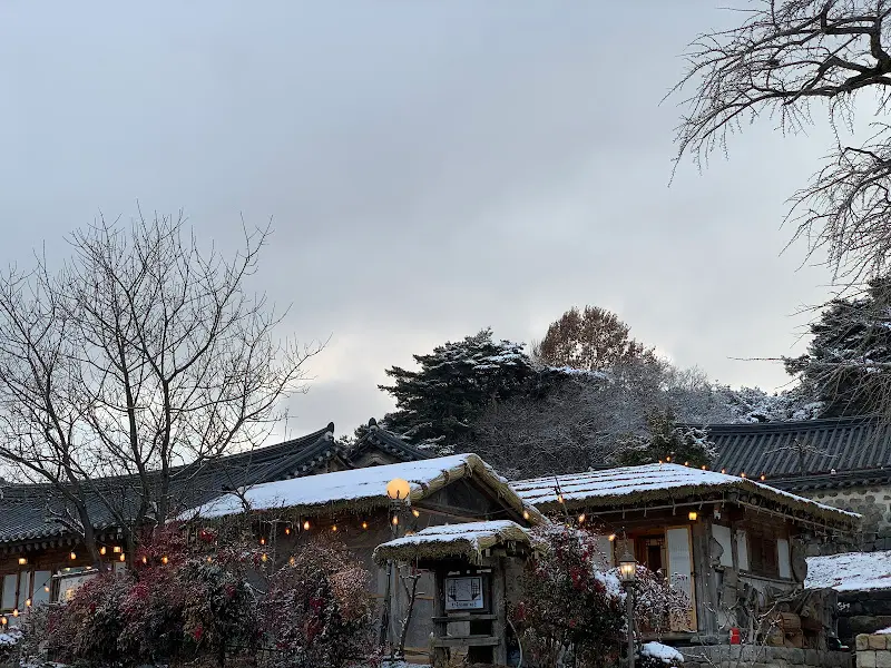 눈 덮인 기와지붕과 따뜻한 조명