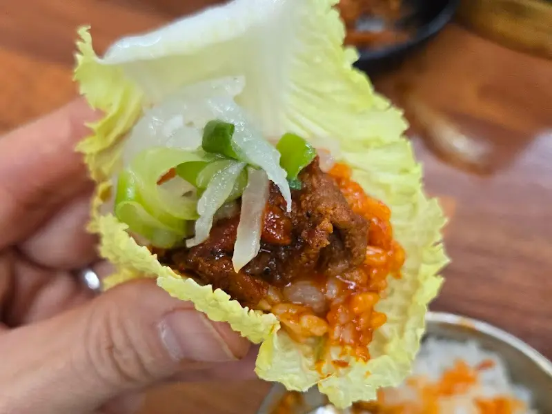 쌈에 밥과 고기를 싸서 먹는 모습