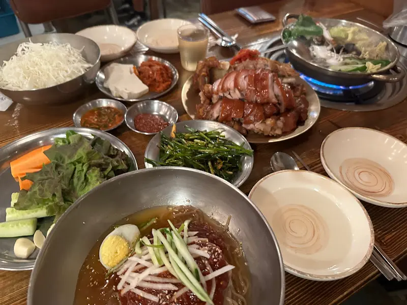 푸짐하게 차려진 한 상, 족발, 막국수, 해물탕, 그리고 다양한 반찬들