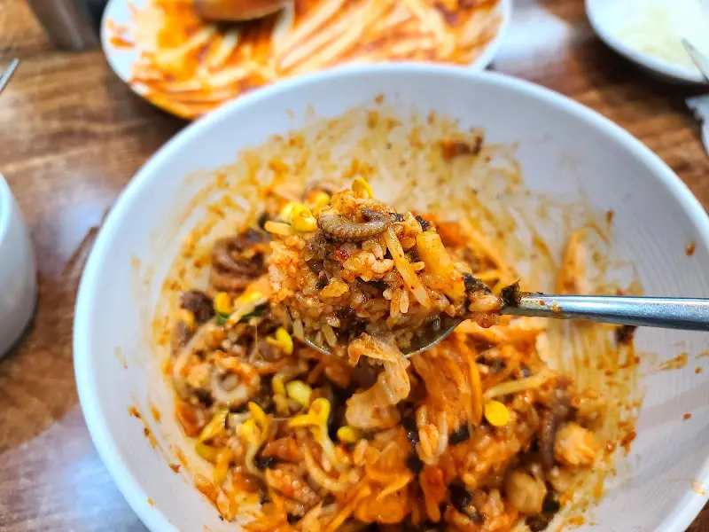 쭈꾸미 볶음과 밥을 함께 비벼 한 입 가득 맛보는 모습