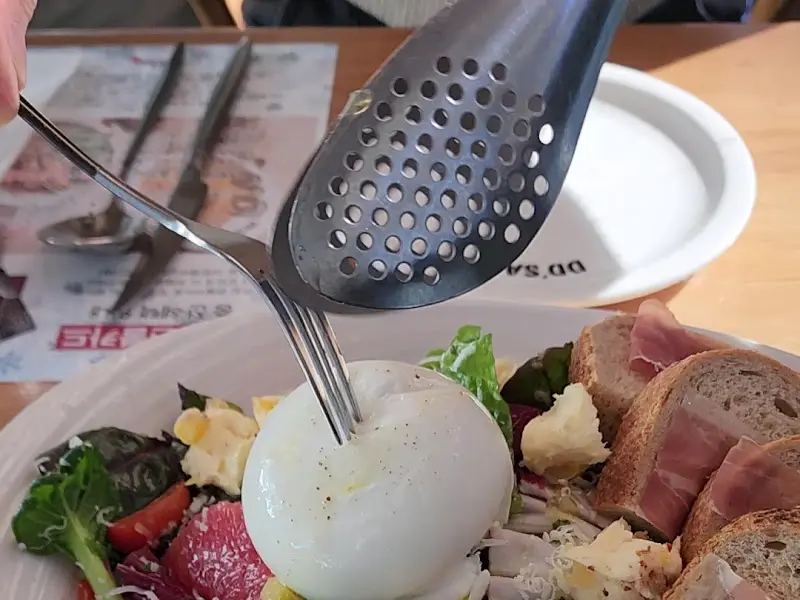 샐러드 속 부라타 치즈를 들어올리는 모습