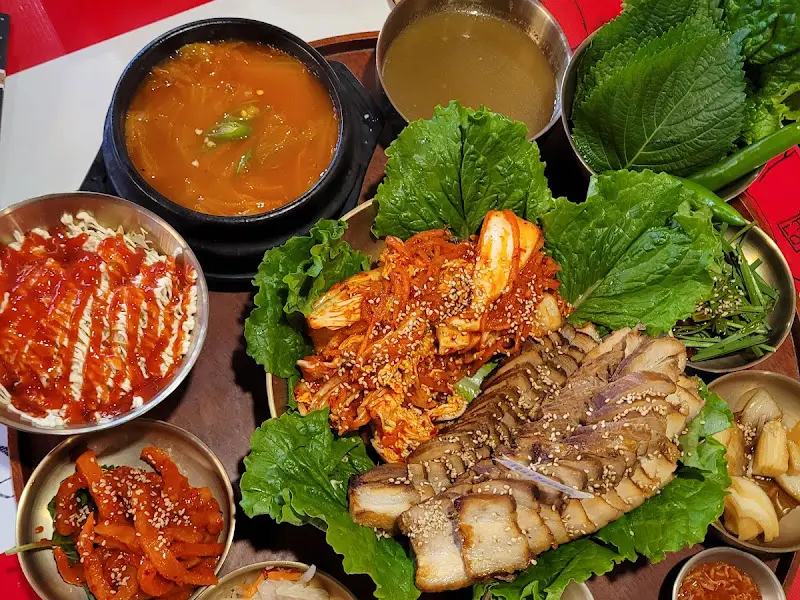 김치 콩나물국과 쌈 채소가 함께 있는 푸짐한 한 상