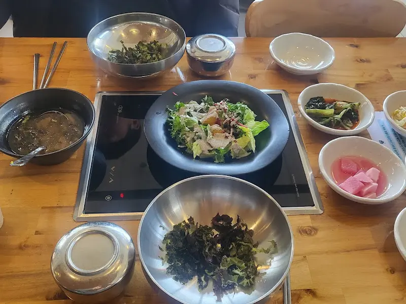 다양한 밑반찬과 샐러드가 테이블 위에 놓여 있는 모습