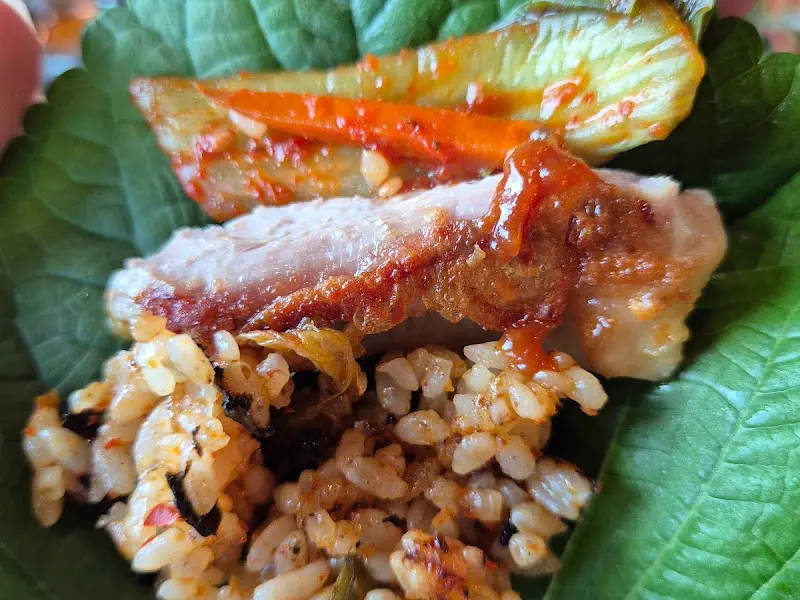 깻잎에 닭갈비와 밥을 싸먹는 모습