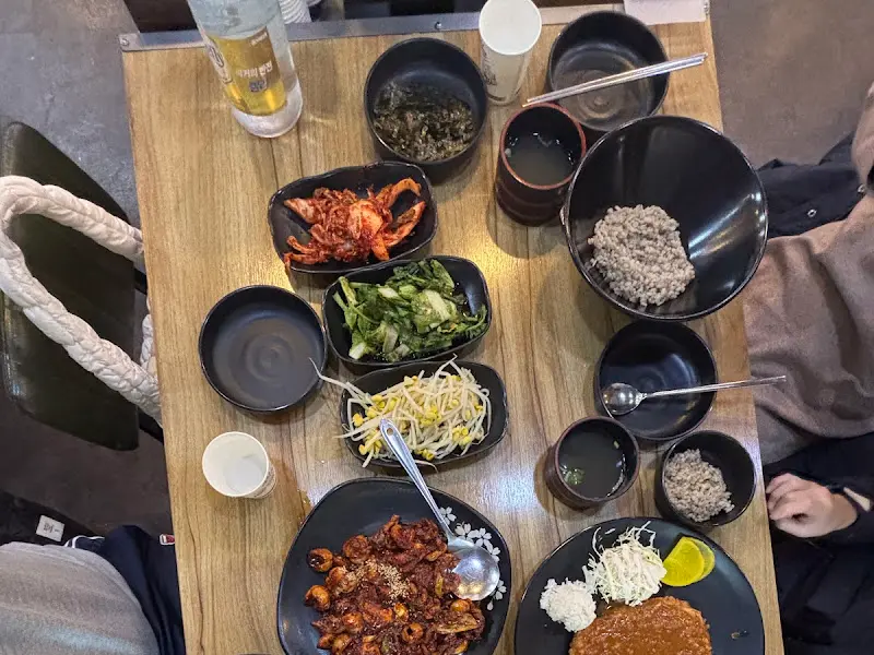 밑반찬과 쭈꾸미볶음, 돈까스가 차려진 테이블