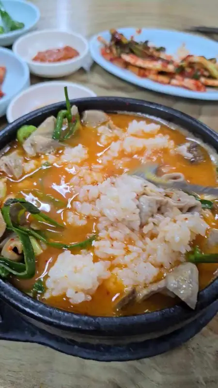 순대국밥에 밥을 말아 파김치와 함께 먹는 모습