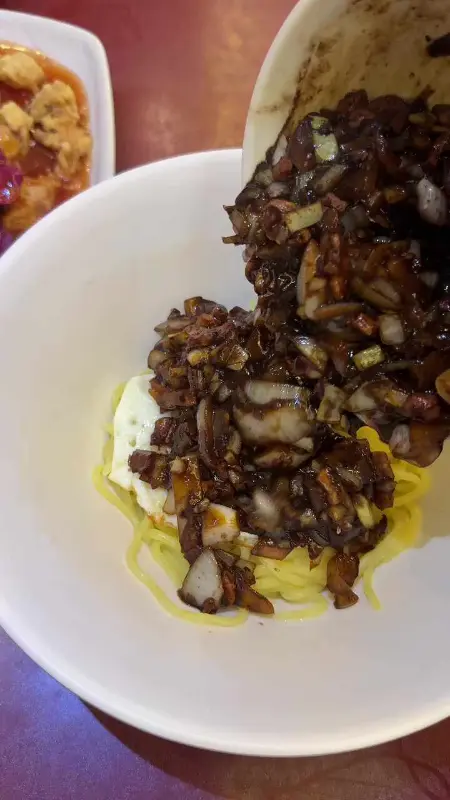 간짜장 소스를 면 위에 붓는 모습