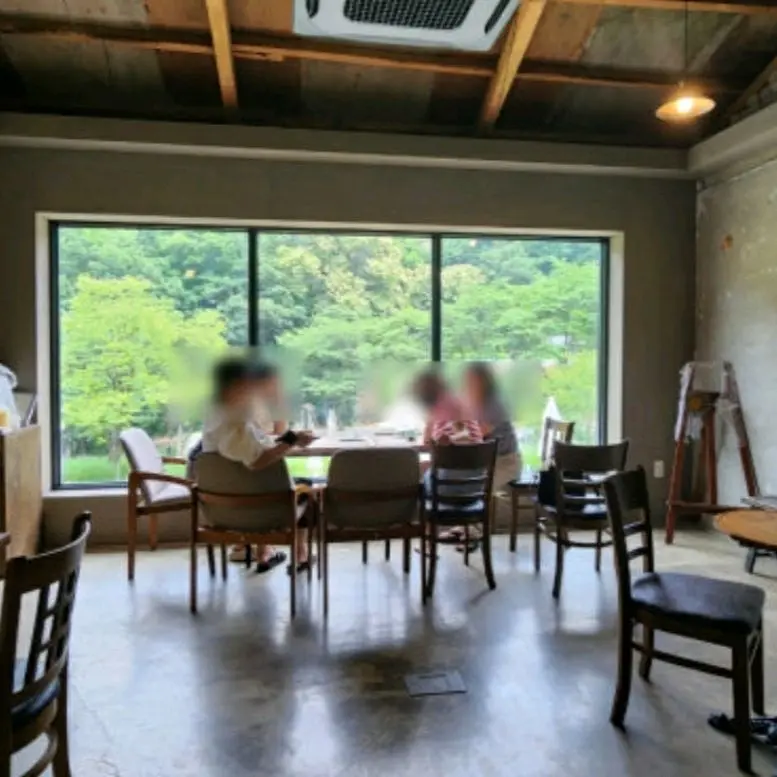 춘의뜰 내부 모습, 넓은 창문과 초록빛 풍경이 인상적이다.