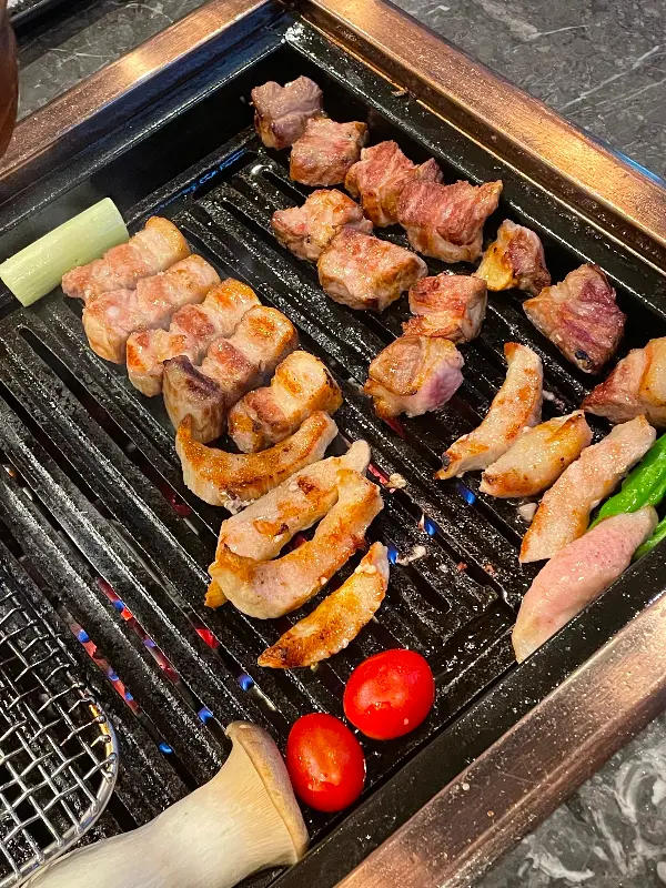 삼겹살, 껍데기, 야채가 구워지는 모습