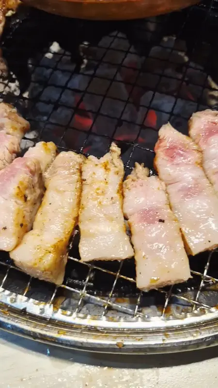 불판 위에 가지런히 놓인 삼겹살